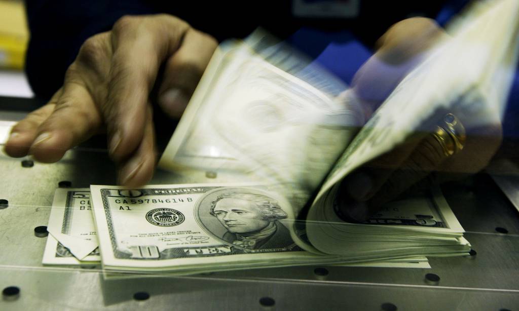 A cashier at a Travelex Bureau de Change counts U.S. dollars in February 2004.