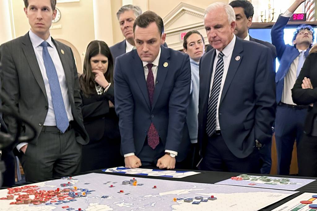 Lawmakers in a new House select committee on China from left, Rep. Jake Auchincloss, D-Mass., Rep. Haley Stevens, D-Mich., committee Chairman Rep. Mike Gallagher, R-Wis., and Rep. Carlos Gimenez, R-Fla., gather for a tabletop war game exercise in the House Ways and Means Committee room on Wednesday, April 19, 2023, in Washington.